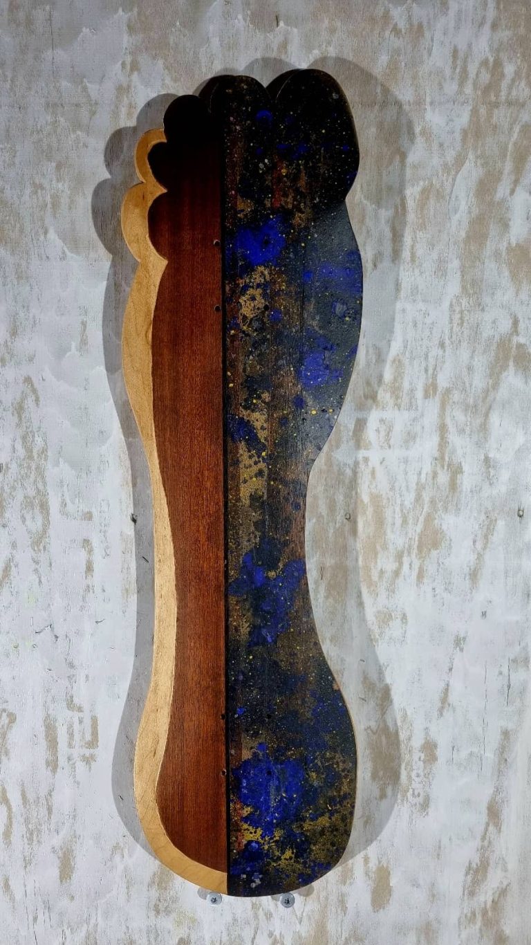 Planche de skate en forme de pied, avec marquetterie d'acajou et peinture à l'huile bleue et jaune astrale sur une moitié.