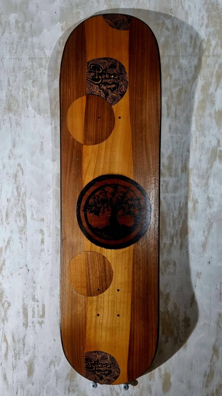 Planche de skate artisanale made in Franche-Comté, marquetée en une oeuvre abstraite de nulles et lignes entrecoupées, agrémentée d'un arbre de vie sérigraphié en son centre.