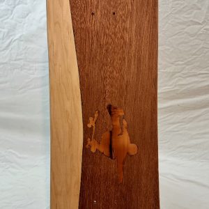 skateboard vu du dessous, présentant en marquetterie une silhouette exécutant un flip ou un one-foot