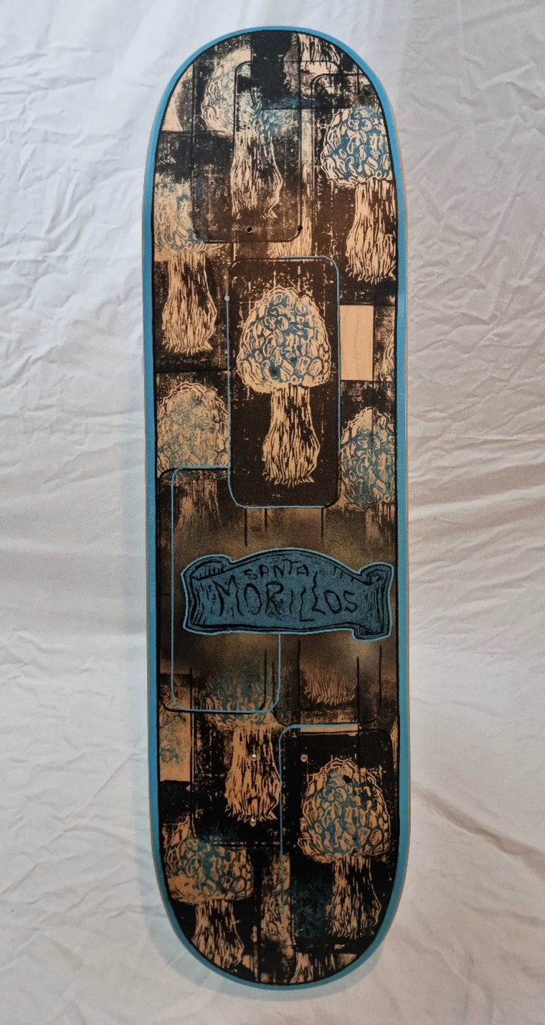 Skateboard vu de dessous et son custom manuel et artisanal. peinture linogravure pour la reproduction des motifs Santa Morillos