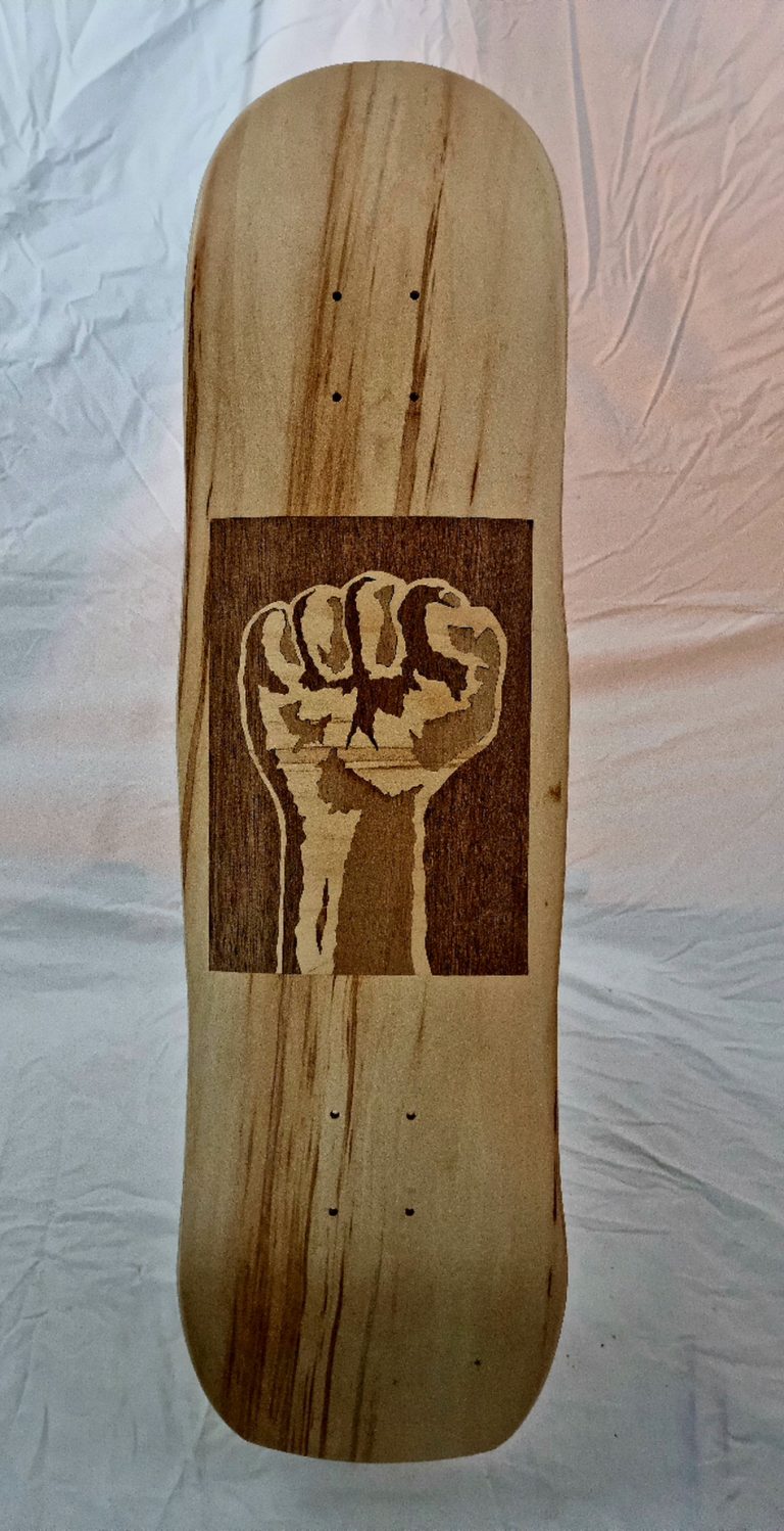 dessous de la planche de skate artisanale et sa marquetterie incrustrée dans le pli visible, le point levé, celui de l'artisant du skate !