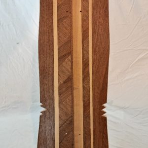 vue de dessous du skateboard made in franche comté, présentantant sa marquetterie et son shape original et artisanal