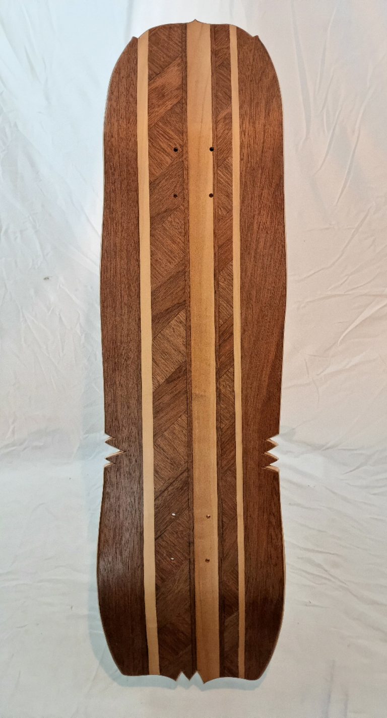 vue de dessous du skateboard made in franche comté, présentantant sa marquetterie et son shape original et artisanal