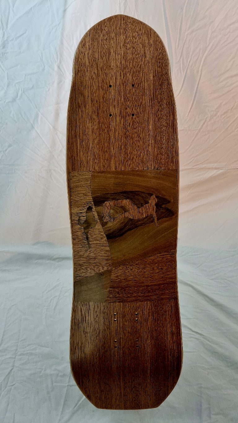 vue de dessous de la planche de skate artisanale et sa marquetterie